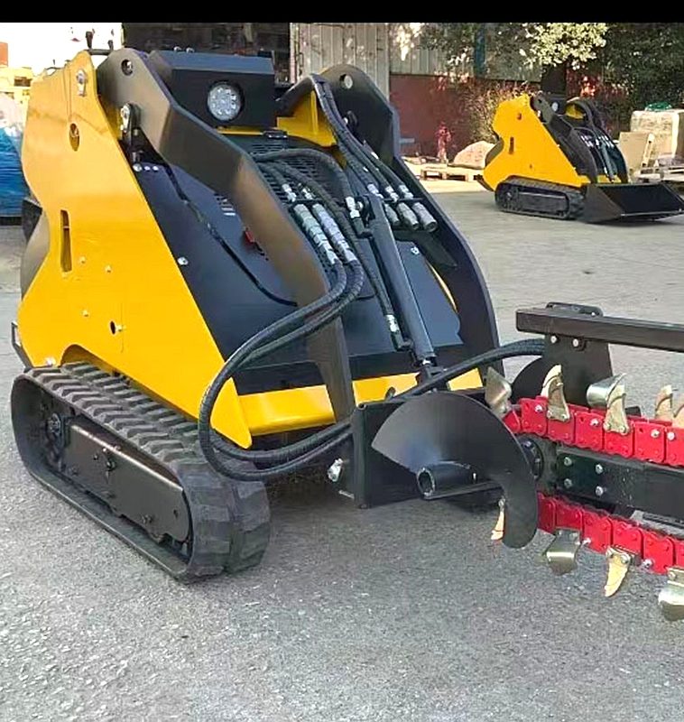 Mini skid steer loader with trencher attachment installed